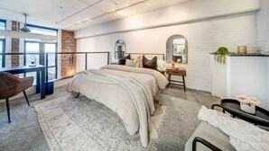 Une chambre à coucher moderne avec un grand lit, un bureau et une chaise.