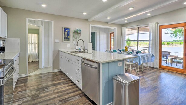 A modern kitchen with a central island, built-in appliances, and a dining area with a view. - Private Dock - Waterfront Lake Brownwood Gem! (Brownwood)