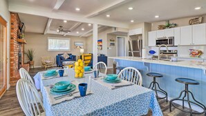 A spacious kitchen with white cabinets, a stainless steel refrigerator, and a blue island with stools. - Private Dock - Waterfront Lake Brownwood Gem! (Brownwood)