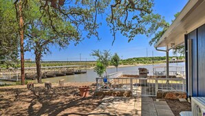 A patio area with a view of a lake, outdoor seating, and a covered area with a railing. - Private Dock - Waterfront Lake Brownwood Gem! (Brownwood)