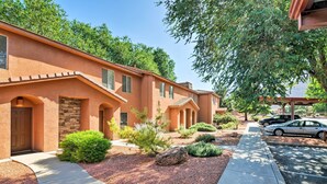 A row of modern, stucco-clad buildings with arched doorways and a landscaped front yard.