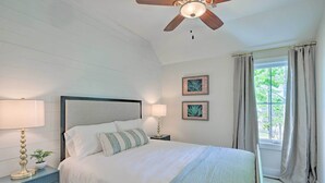 A bedroom with a bed, two bedside tables, a ceiling fan, and a window with curtains. - Luxe Lakefront Getaway w/ Porch + Water View! (Dadeville)