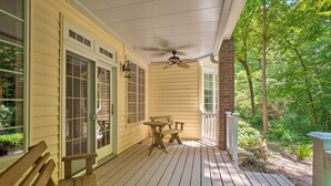 A wooden deck with a ceiling fan, a bench, and a table. - Tellico Village Getaway w/ Theater, Game Room (Loudon)