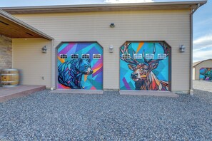 A building with two garage doors featuring colorful animal murals.