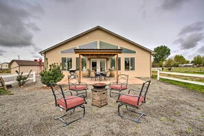 Un edificio con un patio cubierto, mobiliario exterior y una chimenea.