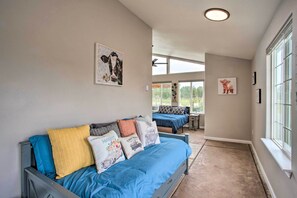Un dormitorio con cama, ventana y ventilador de techo.