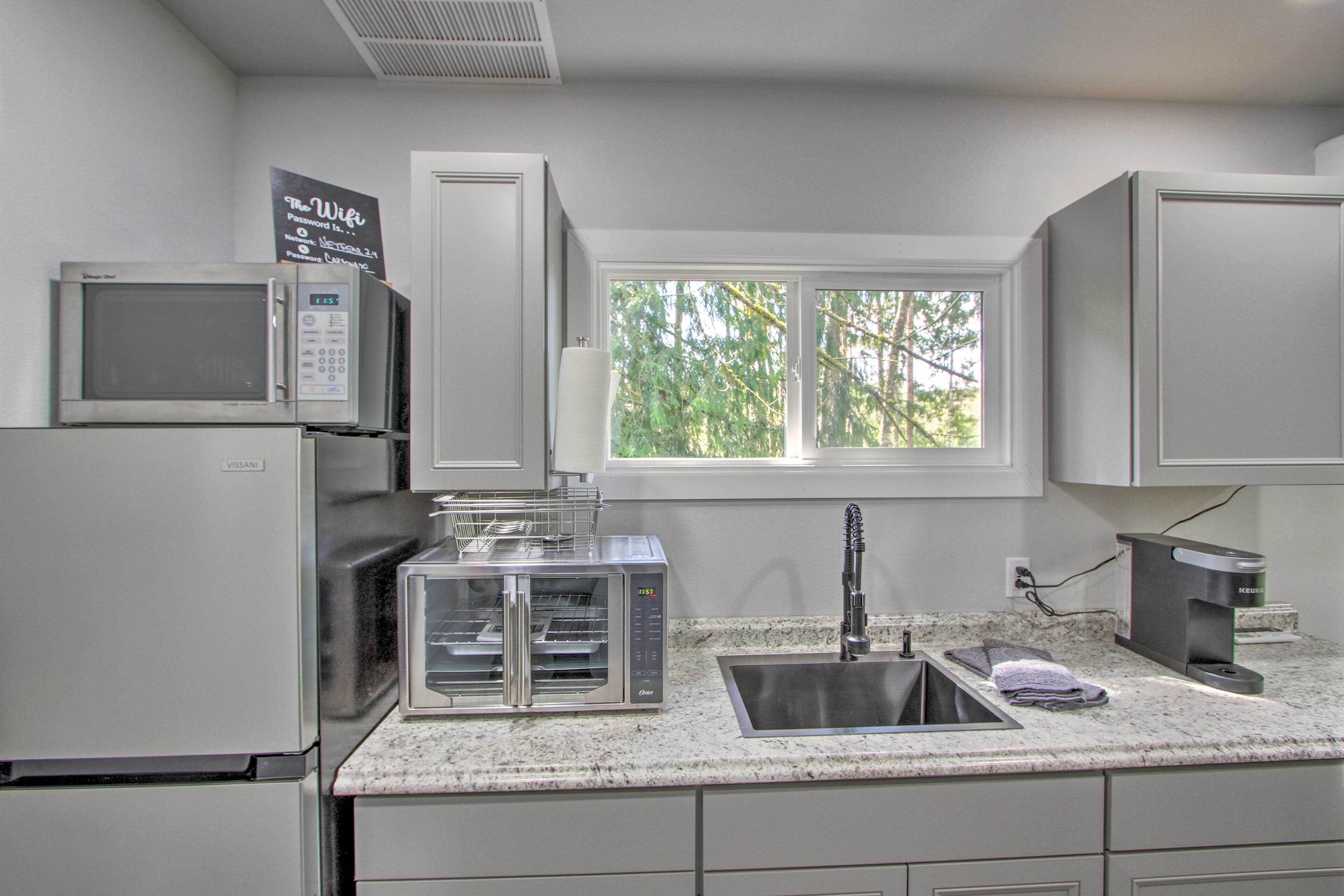 A kitchen with a microwave, toaster, and sink.