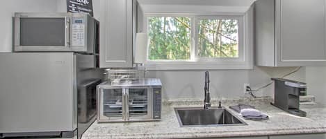 A kitchen with a microwave, toaster, and sink.