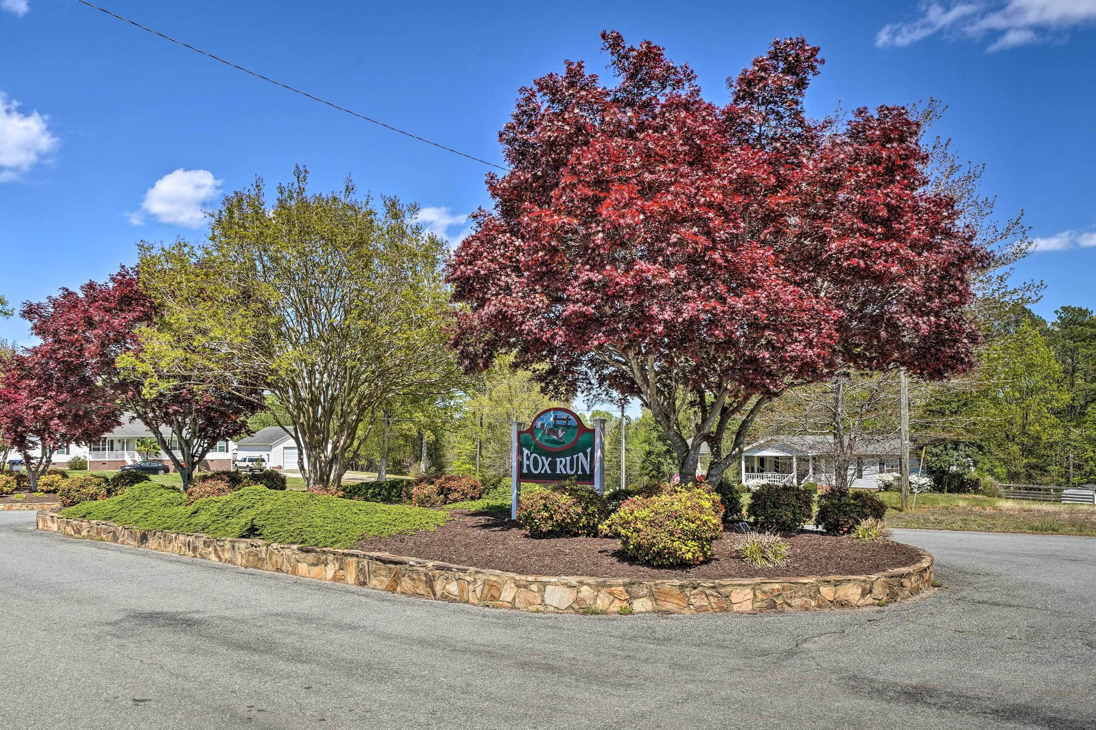 A sign for Fox Run with a stone border and landscaped area.