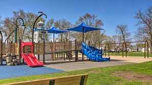A playground with slides, a playhouse, and a bench. - Home on Lake Erie 3 Bedrooms 3 Bathrooms (Port Clinton)