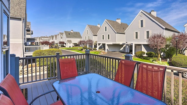 A residential area with a wooden deck, red chairs, and a table. - Home on Lake Erie 3 Bedrooms 3 Bathrooms (Port Clinton)