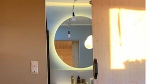 Une chambre à coucher avec un lit, une commode et un miroir.