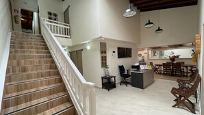 A spacious interior with a wooden staircase, a kitchen area, and a dining space. - Hotel 12 Nights (Medellín)