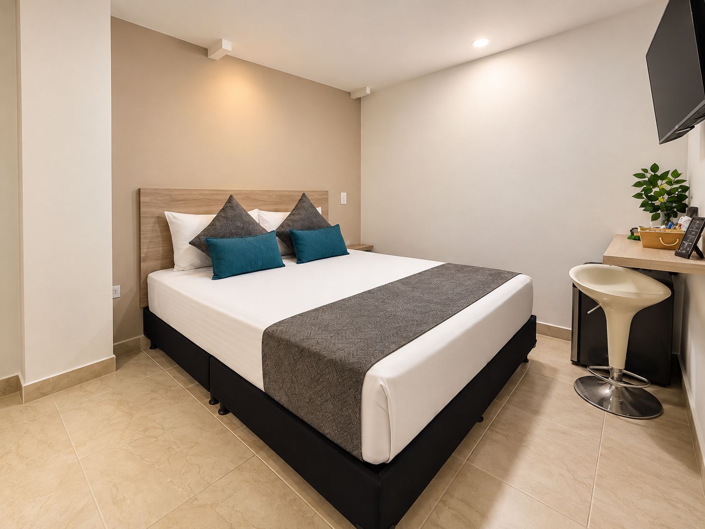 Una habitación de hotel moderna con una cama, un escritorio y una silla.
