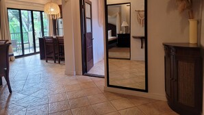 A spacious room with a dining area, a large mirror, and a view of a balcony. - 4th floor Apartment - 2 minutes walking distance to the beach! (Tamarindo)
