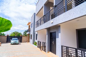 A modern two-story building with a car parked in front. - Modern 2-Bedroom Apartment Home on a Gated Compound with Backup Solar Power. (Amrahia)