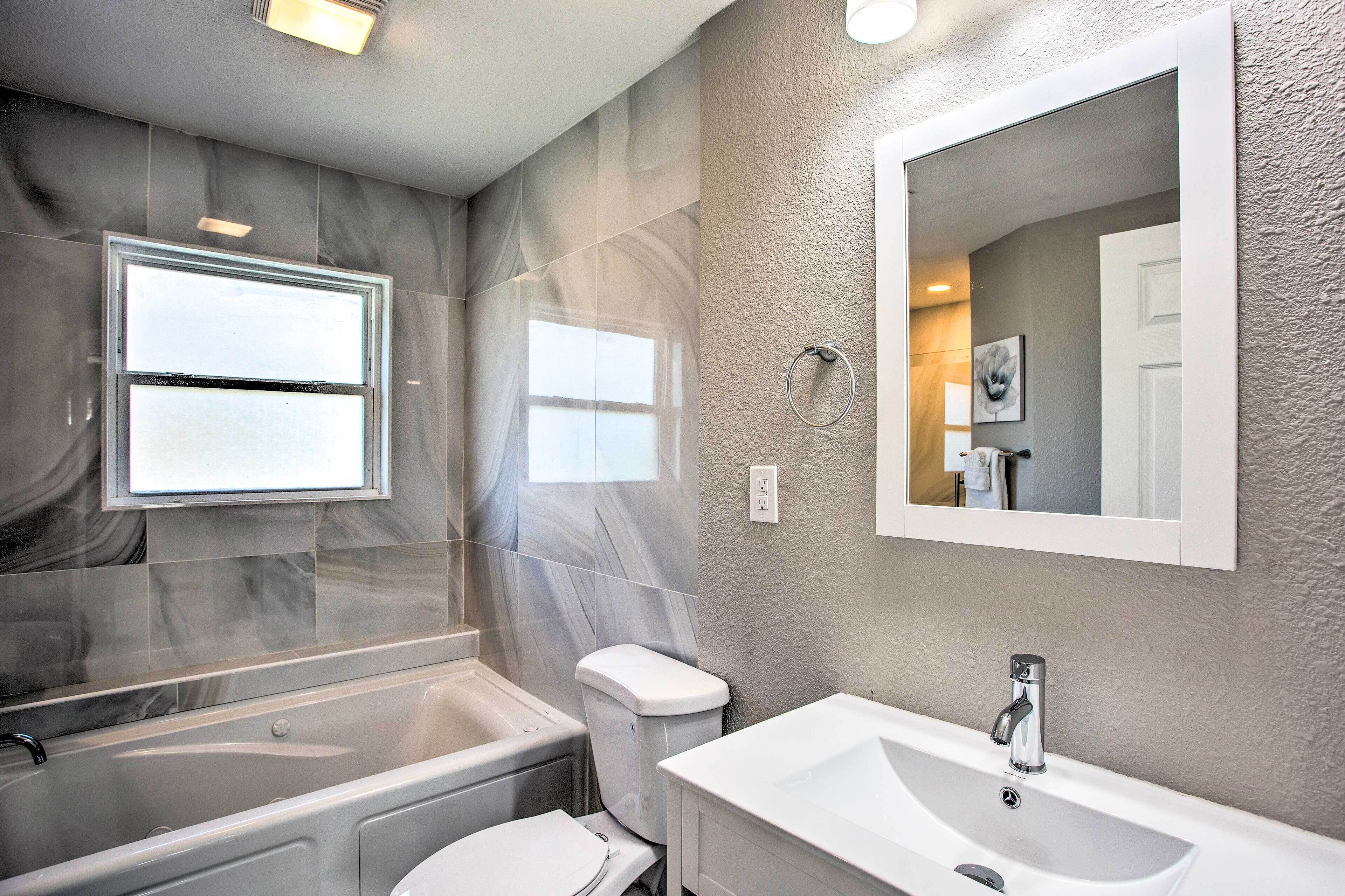 A modern bathroom with a bathtub, toilet, and sink.
