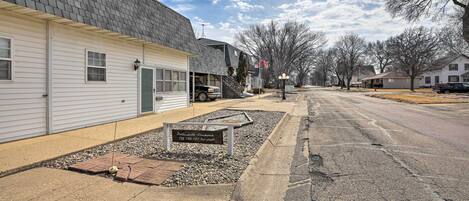 A residential street with houses, a clear sky, and a sign for 'Portlandville Apartments.'