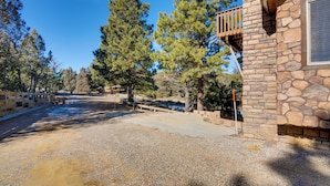 A stone building with a balcony, surrounded by trees and a gravel driveway. - The Bridgeway Casita - Apt Near Natl Parks (Duck Creek Village)