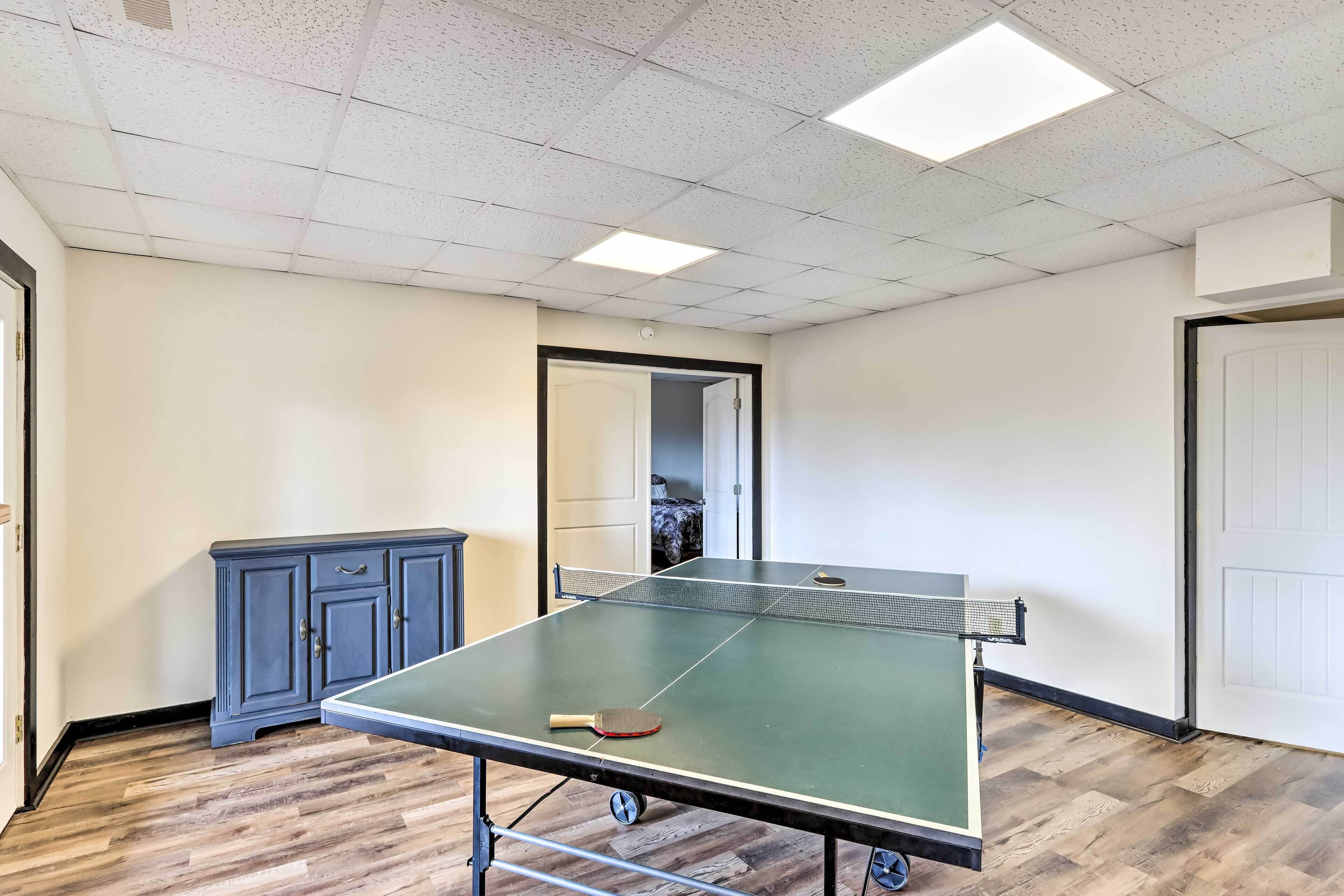 A room with a ping pong table, a cabinet, and a door.