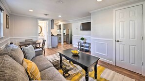 A modern living room with a sofa, a coffee table, and a dining area. - Bay Shore Vacation Rental ~ 7 Mi to the Beach (Bay Shore)