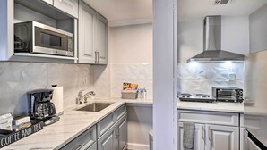 A modern kitchen with a built-in microwave, coffee maker, and a stainless steel range hood. - Bay Shore Vacation Rental ~ 7 Mi to the Beach (Bay Shore)