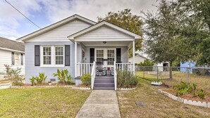 A two-story house with a front porch, a covered entryway, and a small garden area.