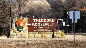 En skylt för Theodore Roosevelt nationalpark med en pil som visar riktningen.