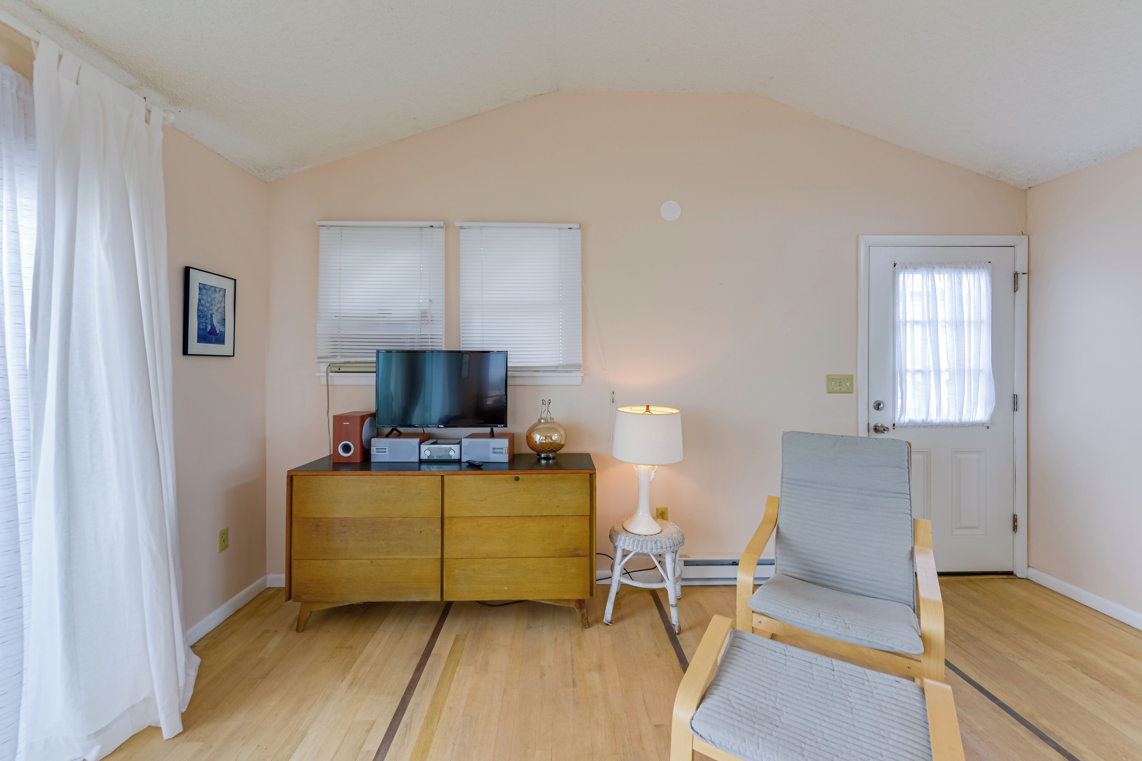 Ein Zimmer mit einem Holzkasten, einem Fernseher, einer Lampe und einem Stuhl.