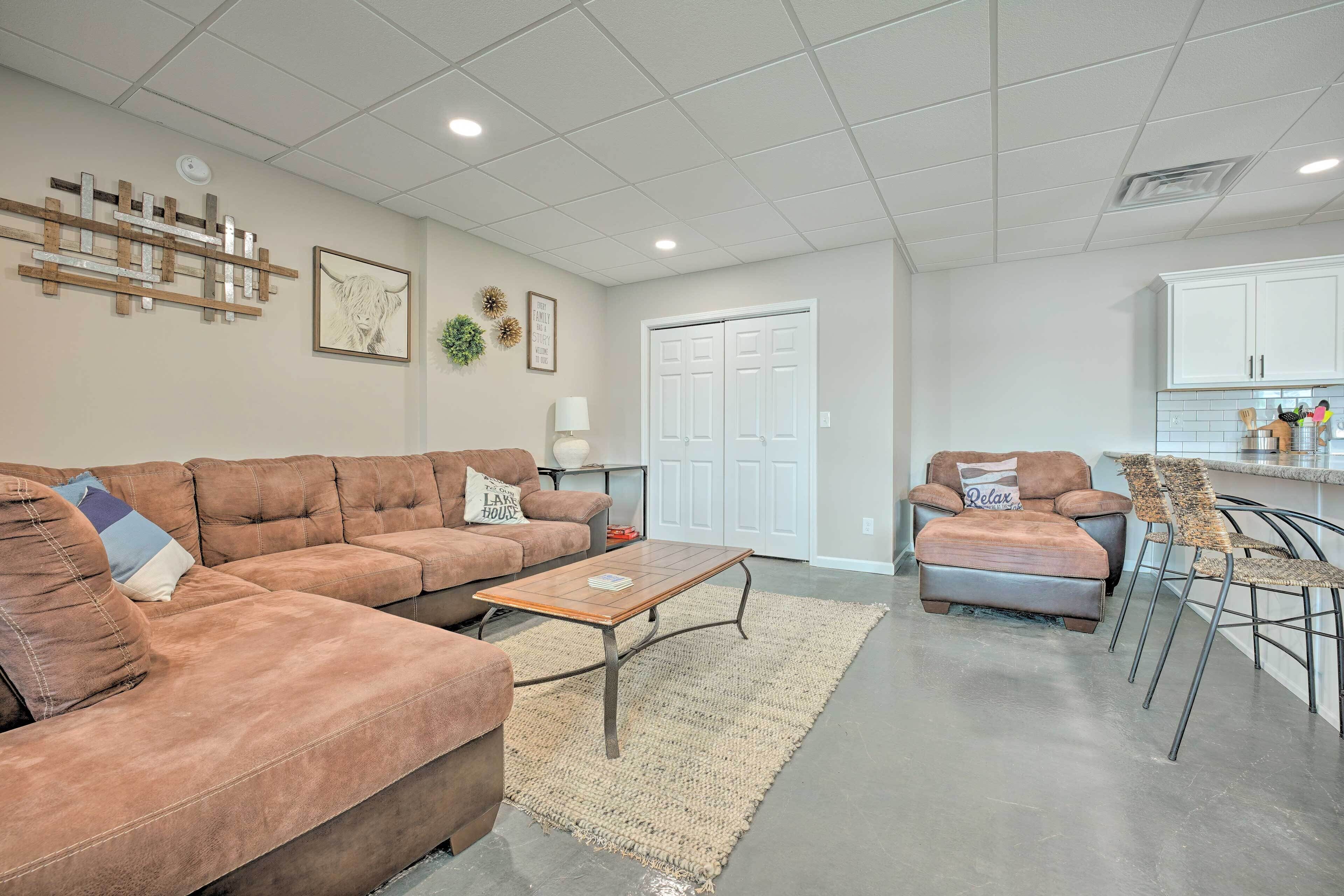 A modern living room with a sectional sofa, a coffee table, and a dining area with chairs.