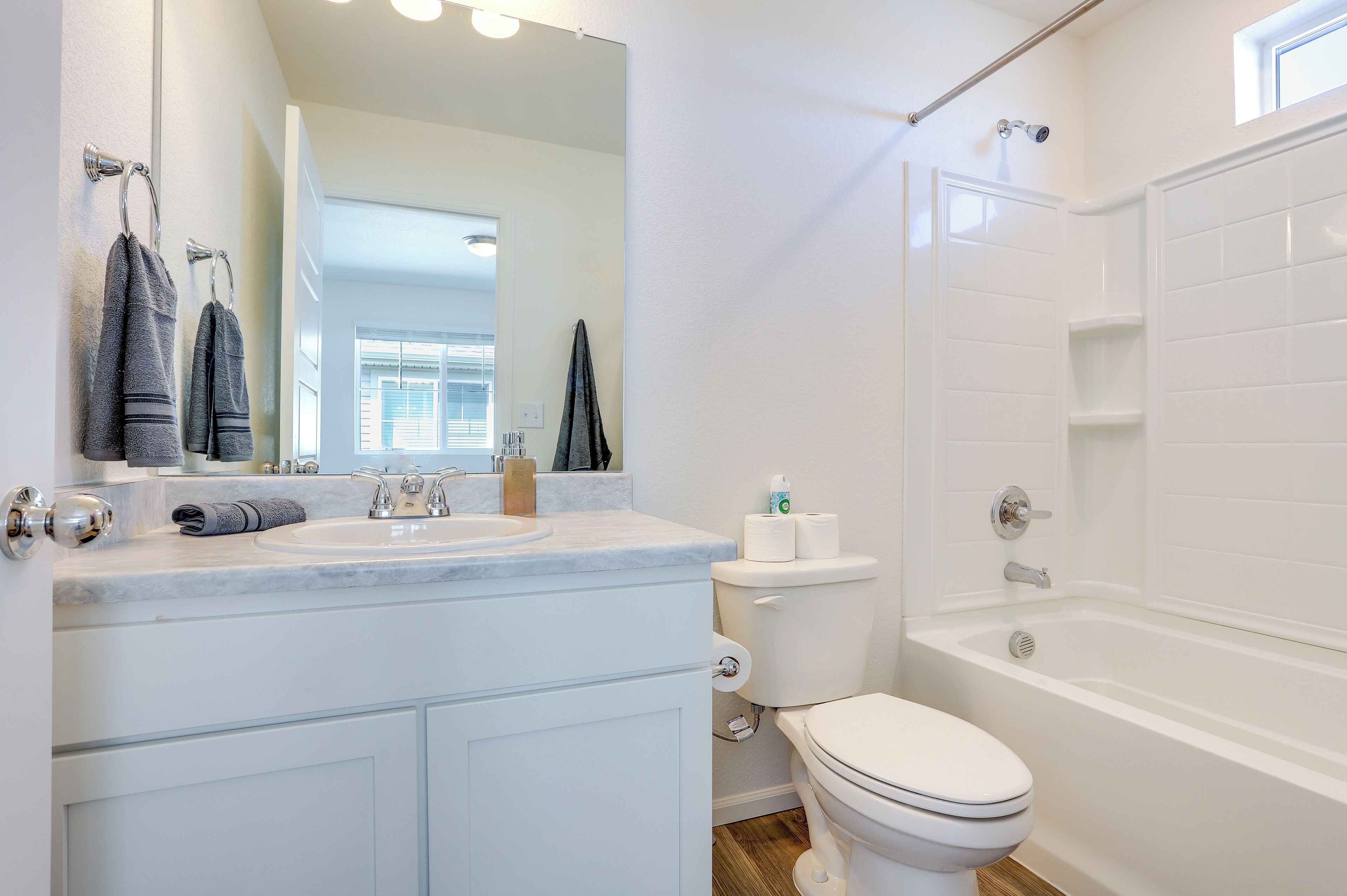 A modern bathroom with a white sink, toilet, and bathtub.