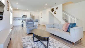 A modern living room with a sofa, coffee table, and a staircase leading to another level. - Colorado Retreat Near Hiking, Golfing & Fishing! (Commerce City)