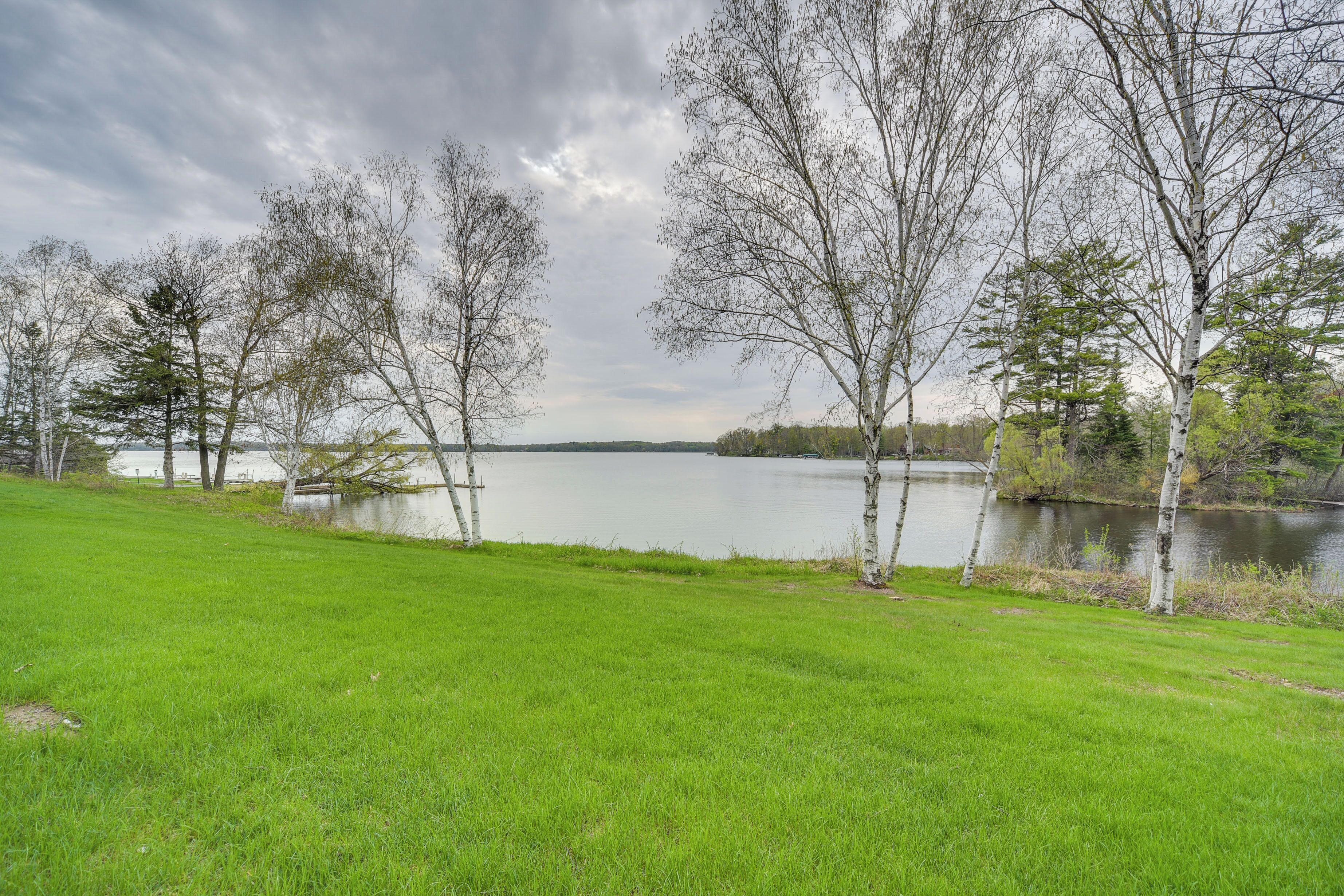 Eine grüne Wiese mit Bäumen und einem See.