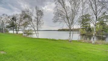 Eine grüne Wiese mit Bäumen und einem See.