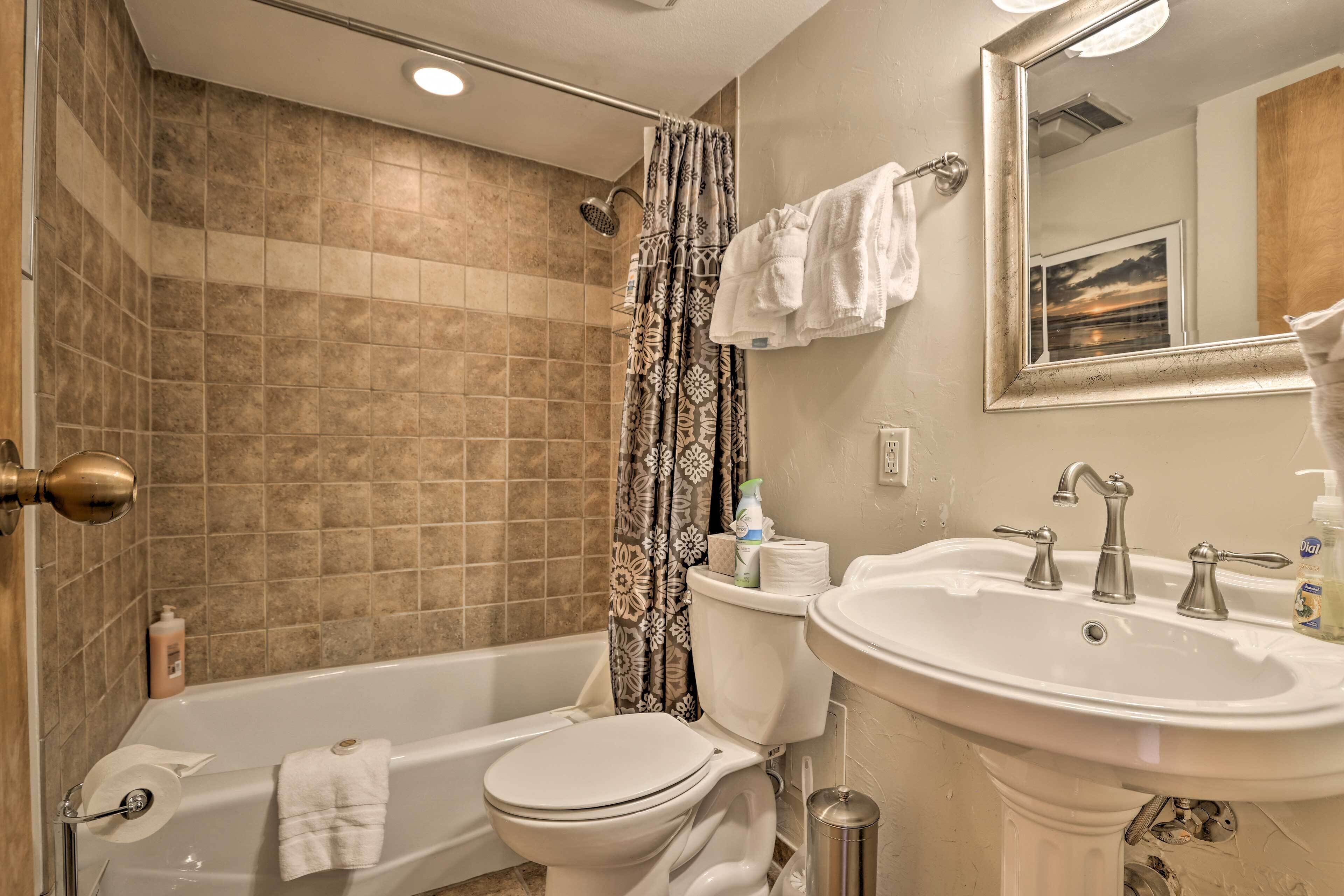 A bathroom with a bathtub, toilet, and sink.