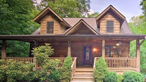 A wooden cabin with a porch, steps leading to the entrance, and a small garden area with shrubs and a tree. - Charming Mtn Cabin 2 Mi From Downtown Boone! (Boone)