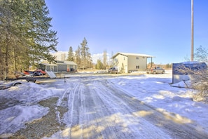 A snow-covered road with buildings and trees in the background.