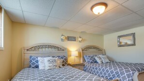 A double bed with a patterned bedspread, two bedside tables with lamps, and a mirror on the wall. - Cozy Historic Home w/ Games, Near Bryce Canyon! (Cannonville)