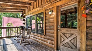 A wooden cabin with a porch, rocking chairs, and a large wooden door. - Family-friendly Gatlinburg Cabin w/ Pool Access! (Gatlinburg)