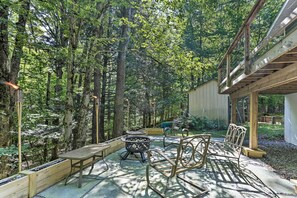Une terrasse extérieure avec des meubles en bois, un foyer et une plateforme en bois.