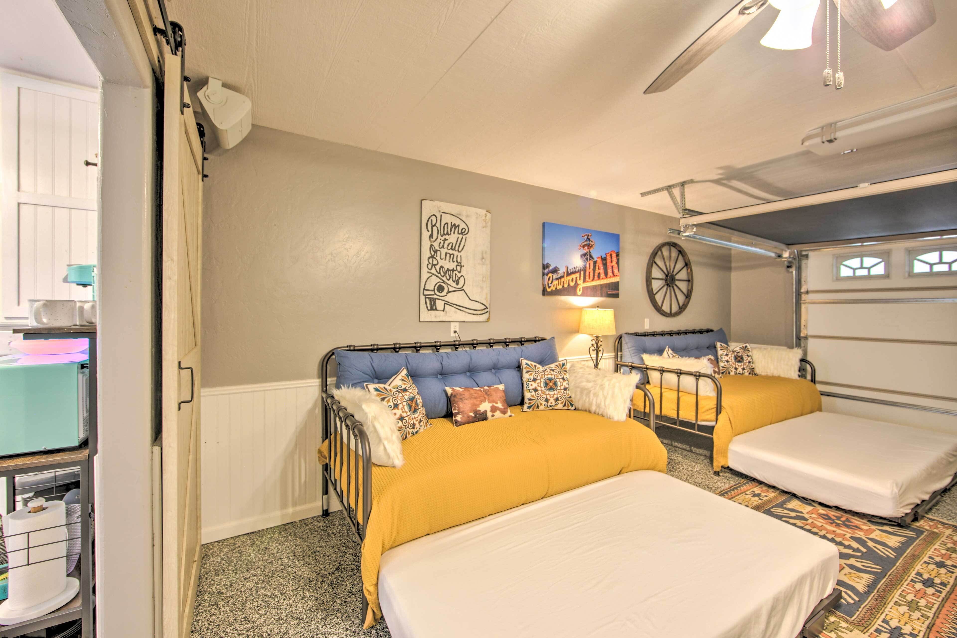 A hotel room with two beds, a desk, and a chair. There are wall decorations, including a sign and a picture.