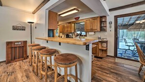 Eine Küche mit Holzhocker, einer Arbeitsplatte und Blick ins Freie.
