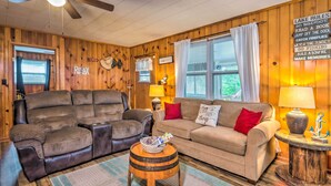 A cozy living room with a leather sofa, a beige couch, and a wooden coffee table. - Cozy Kentucky Cabin w/ Sunroom, Yard & Views! (Cub Run)