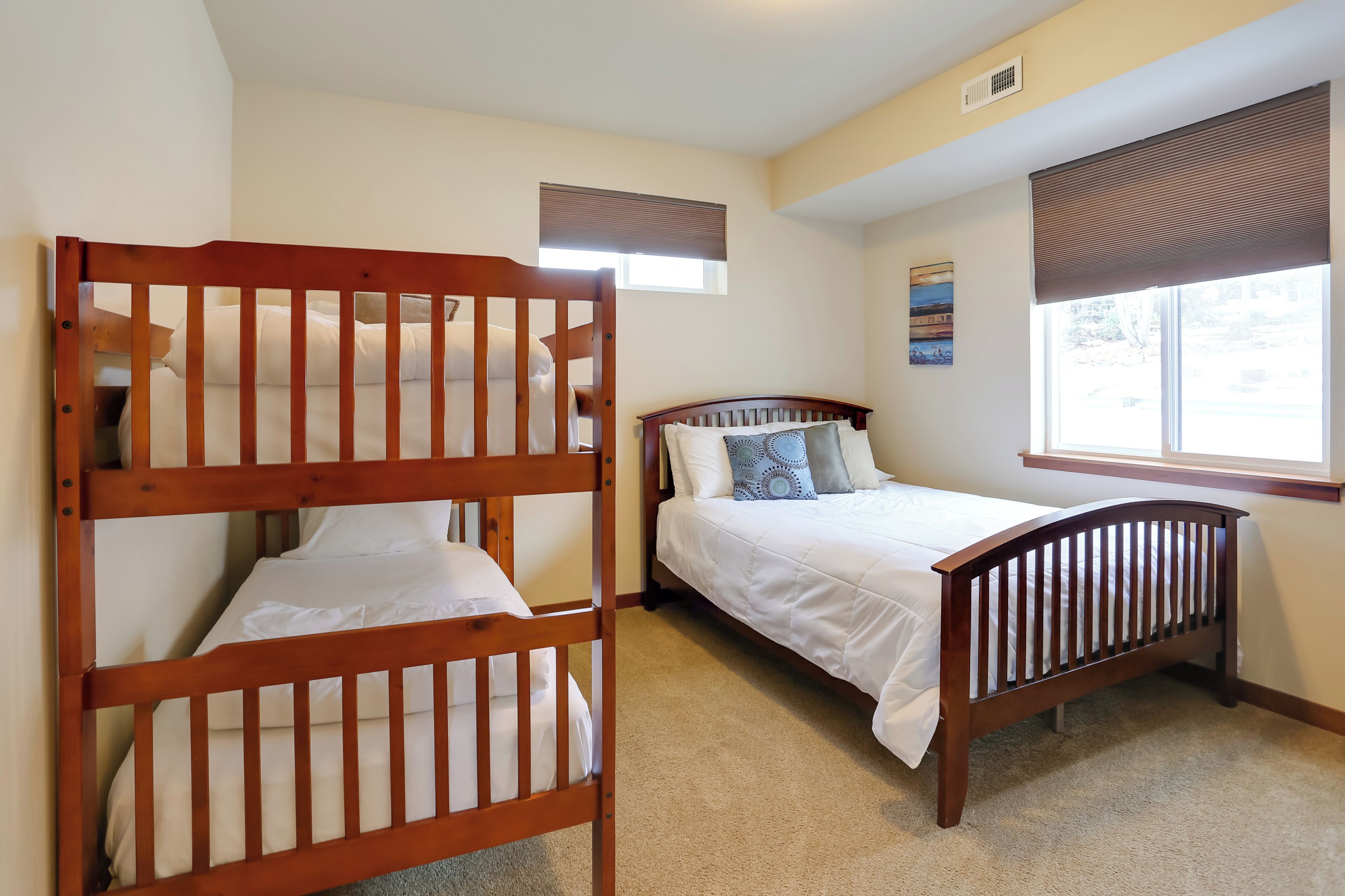 A bedroom with two wooden bunk beds and a single bed.