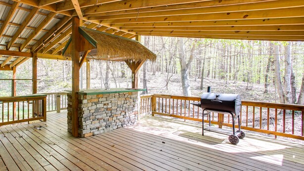 A covered outdoor deck with a stone wall and a grill. - Burkesville Vacation Rental - 5 Mi to the Lake! (Burkesville)
