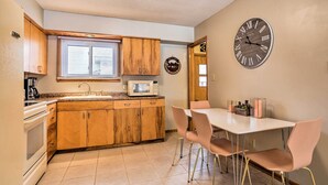 Una cocina con armarios de madera, un microondas y un reloj en la pared.