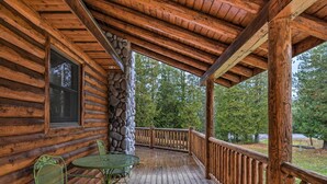 A wooden cabin with a stone pillar, a covered porch, and a view of trees. - 'camp Tony' w/ Trail Access: Walk to Lake Huron! (Millersburg)