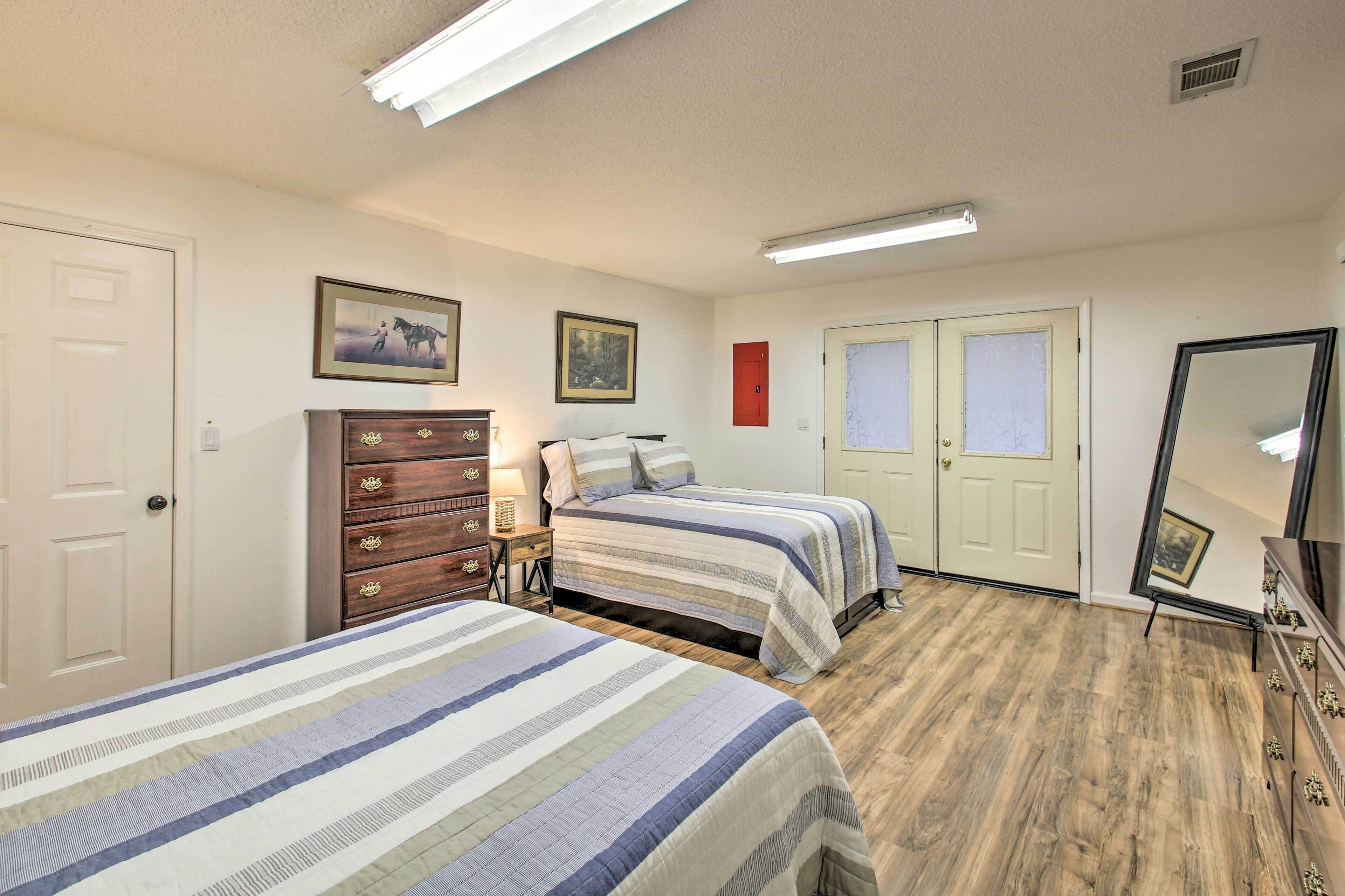 Une chambre avec deux lits, une commode, un miroir et une porte.