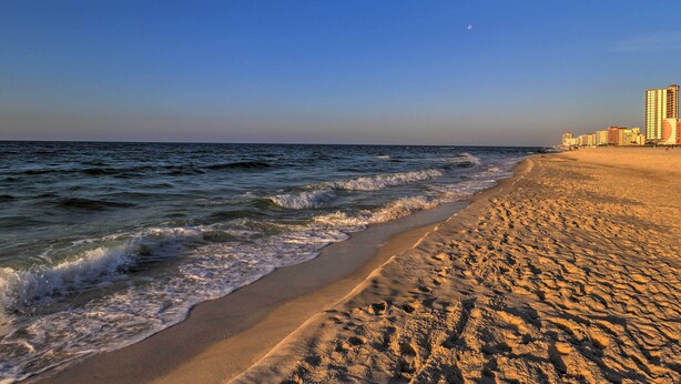A beach with a clear sky and ocean waves. - 1 Mi to Beach Access: Spacious Orange Beach Duplex (Orange Beach)