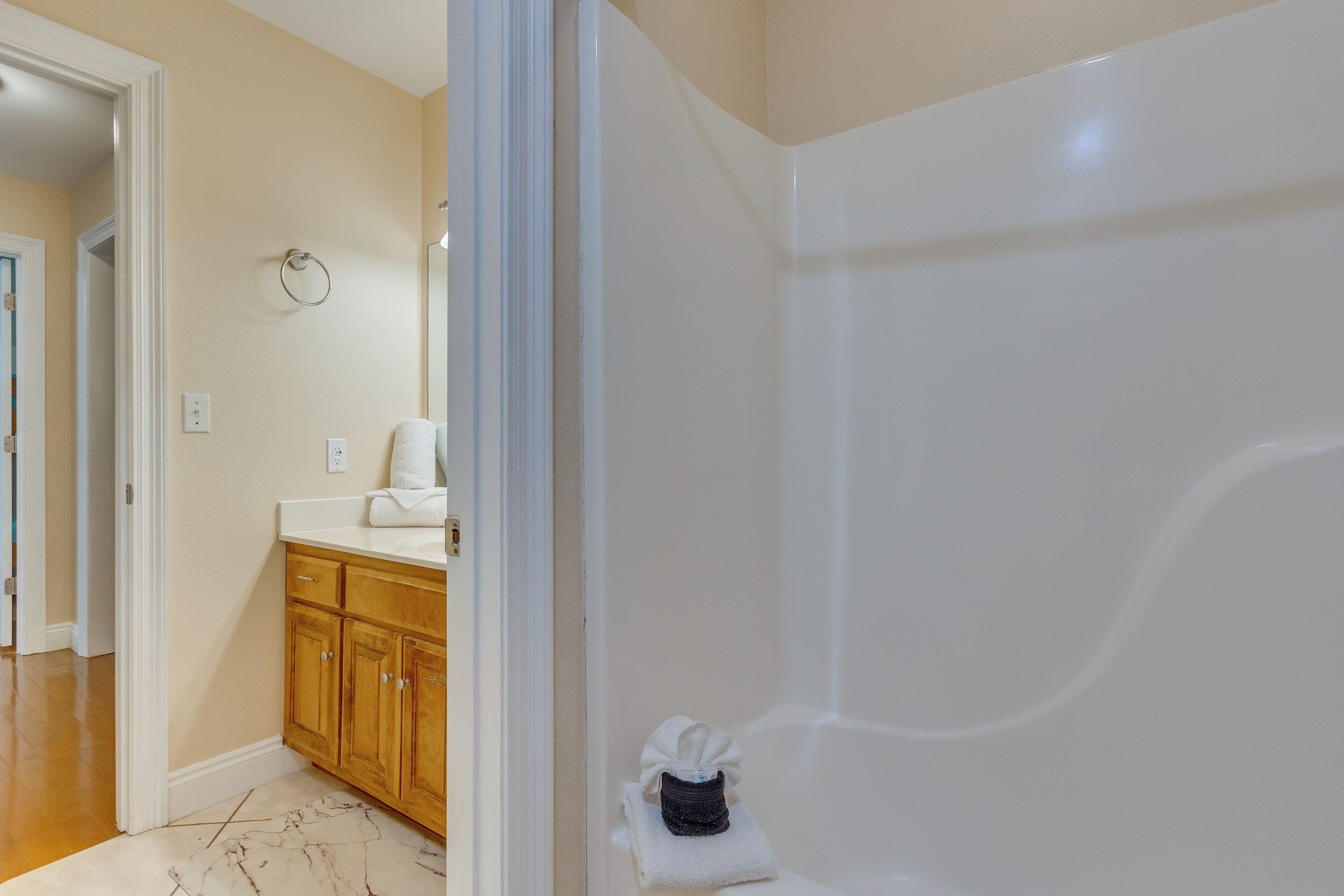 Une salle de bain avec une baignoire, des meubles en bois et un sol en marbre.